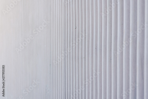 Wavy metal background on a gray wall.