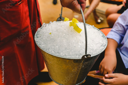 Waiter carrying a metal bucket full of ice to cool drinks in summer. photo