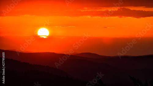 A wonderful sunset in the mountains. Orange sky and dark silhouettes of mountains. Carpathian Mountains landscape. Bieszczady. Poland