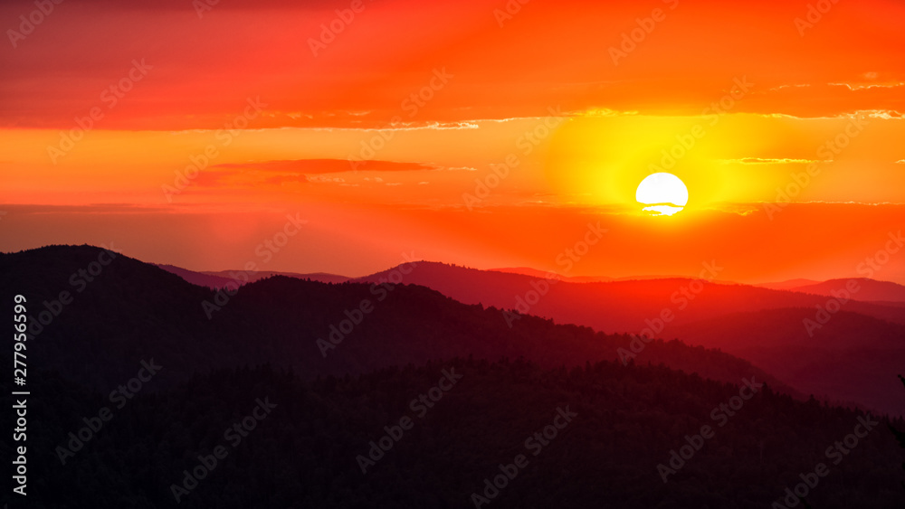 A wonderful sunset in the mountains. Orange sky and dark silhouettes of mountains. Carpathian Mountains landscape. Bieszczady. Poland A wonderful sunset in the mountains. Orange sky and dark silhouettes of mountains. Carpathian Mountains landscape. Bieszczady. Poland