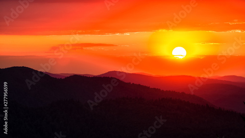 Fototapeta Naklejka Na Ścianę i Meble -  A wonderful sunset in the mountains. Orange sky and dark silhouettes of mountains. Carpathian Mountains landscape. Bieszczady. Poland
