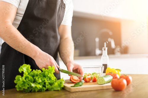 Young trendy man cooking healthy food in the morning
