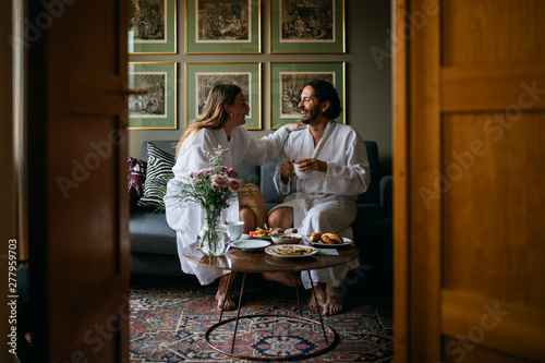 Happy couple in bathrobes in hotel room photo