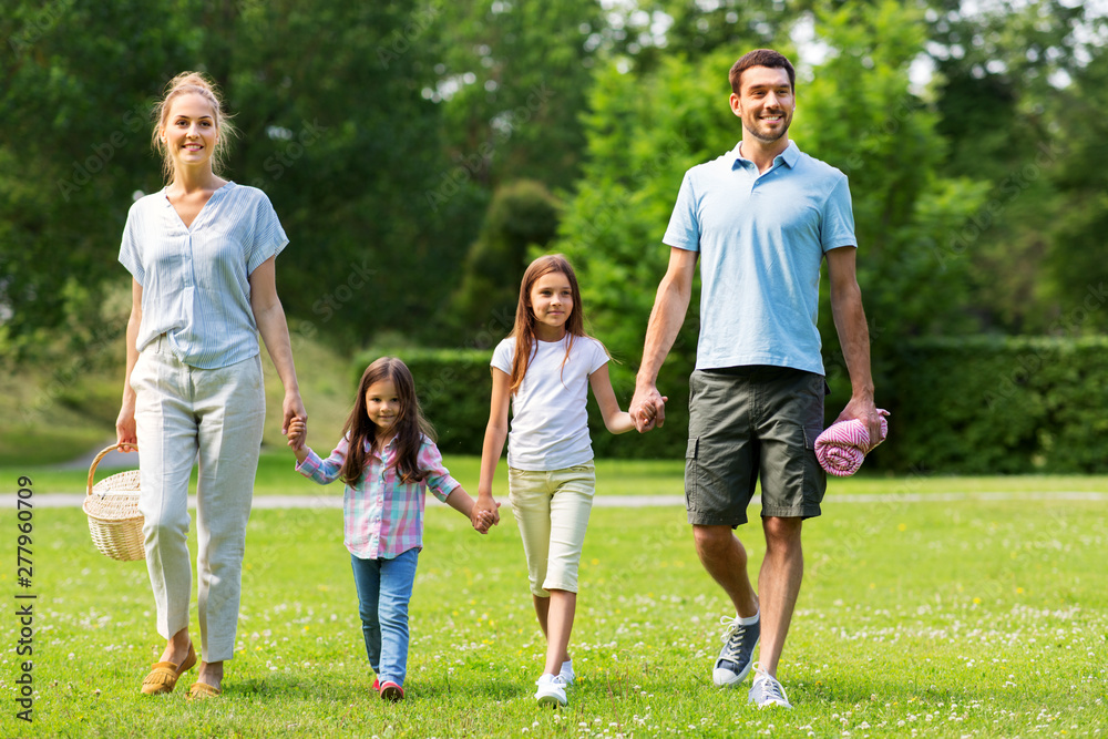 family, leisure and people concept - happy mother with picnic basket, father and two daughters walking in summer park family, leisure and people concept - happy mother with picnic basket, father and two daughters walking in summer park