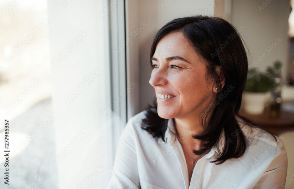 Mature woman looking out of window Mature woman looking out of window
