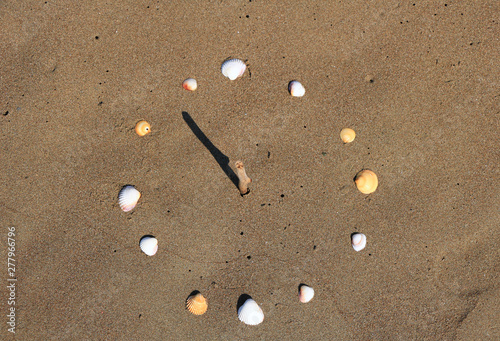 Fototapeta Naklejka Na Ścianę i Meble -  Sundial on beach made of seashells, and a twig. At the Mediterranean beaches, Turkey