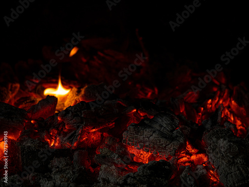 glowing embers of oak wood in the fireplace, with flame