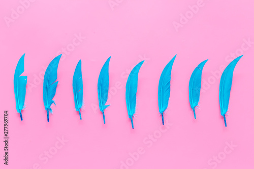 colorful feathers pattern on pink background top view copyspace