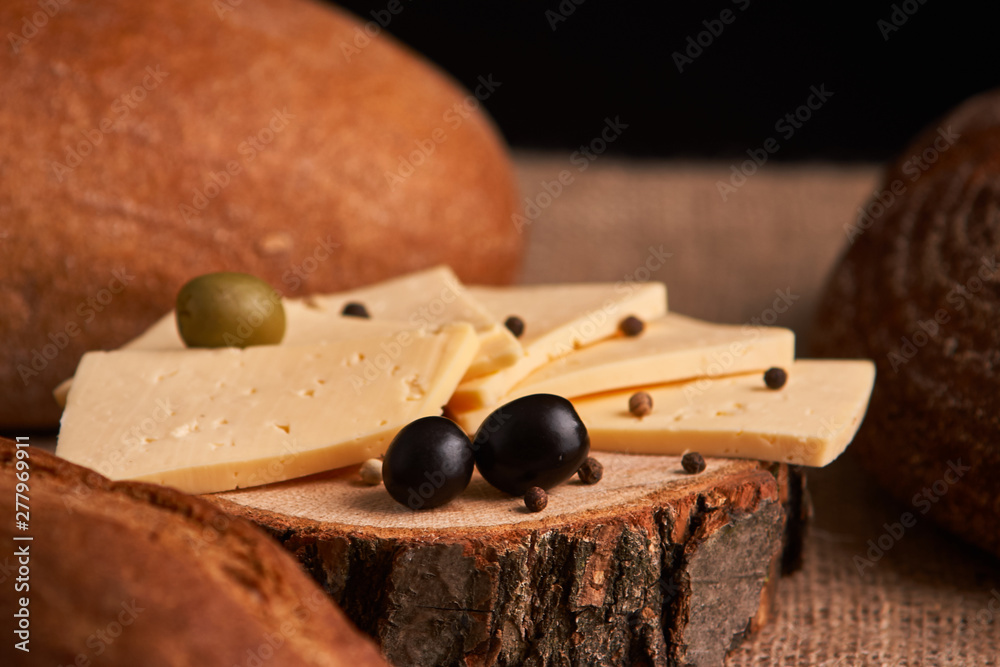 Slices of cheese on wooden desk between different breads. place for text