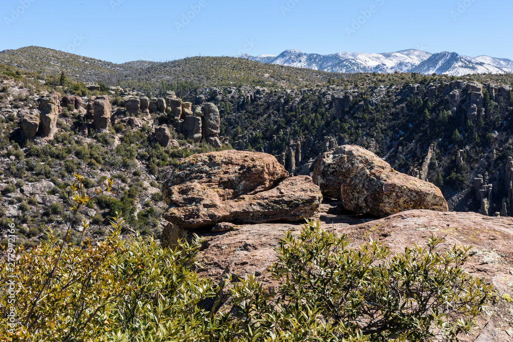 Rock pinnacles afford grand views of snow covered peaks and the valley below in Chiricahua National Monument in Southeastern Arizona.