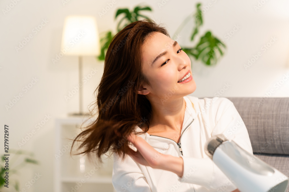 ドライヤーで髪を乾かす女性 ドライヤーで髪を乾かす女性