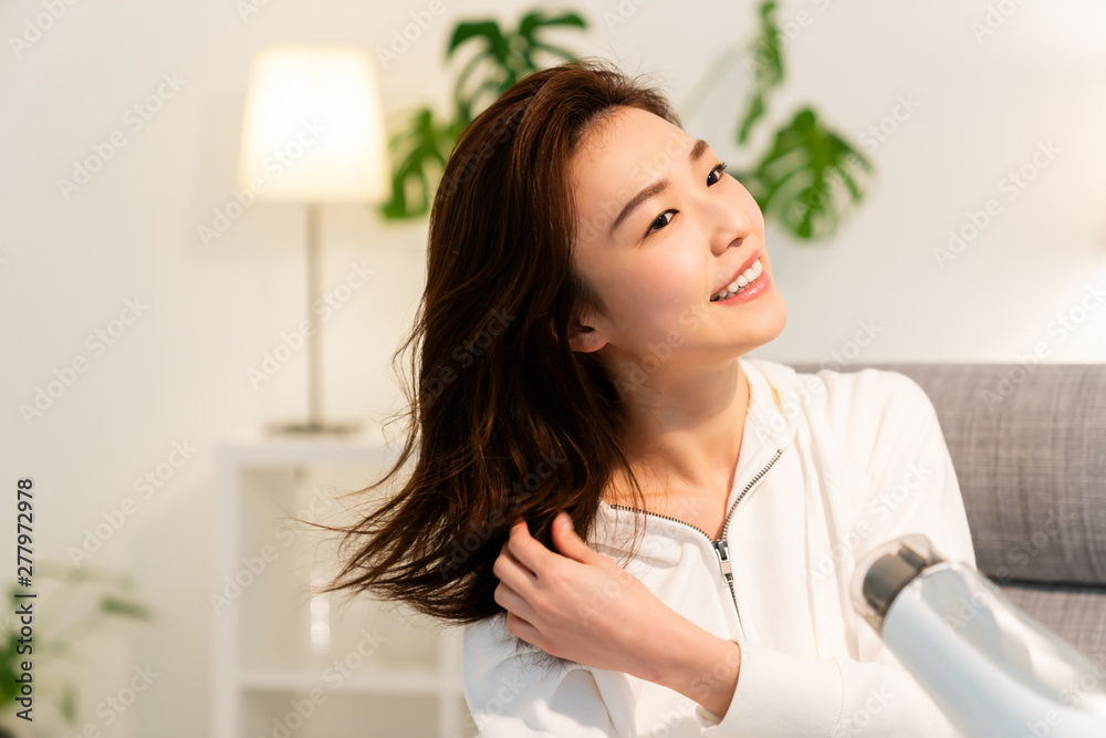 ドライヤーで髪を乾かす女性 ドライヤーで髪を乾かす女性