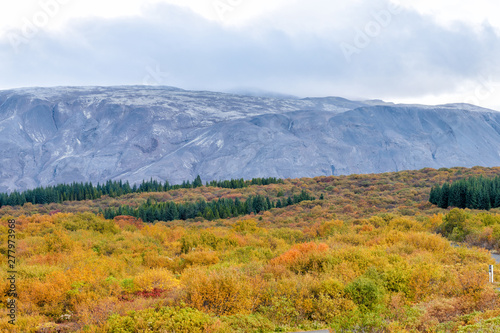 Landscape view of Thingvellir mountains or Thingvallavatn on Golden circle in Iceland with clouds covering summit range in park with autumn foliage