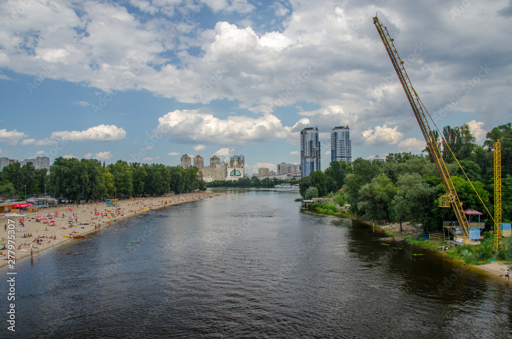 Obraz premium Plaża nad Dnieprem w pobliżu kompleksu Hydroparku z apartamentowcami w tle, Kijów, Ukraina