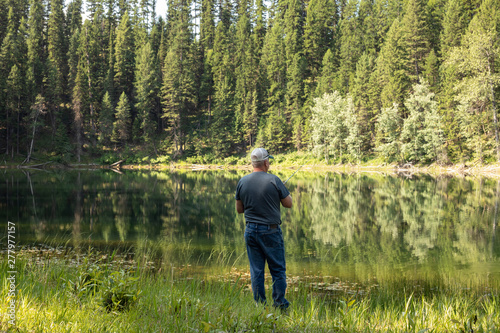 man fishing at a lake in the forest 