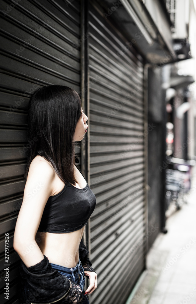路地裏に佇むセクシーで若い日本人女性