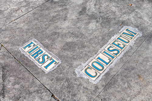 Sign for First and Coliseum street road on sidewalk pavement or road in Garden District of New Orleans, Louisiana