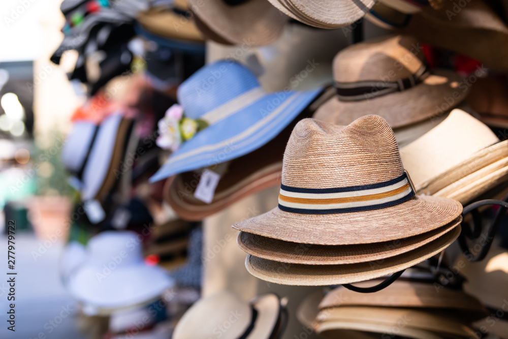 Stack stacked fedora man straw hats on retail display of street vendor store with many colors in New Orleans, Louisiana