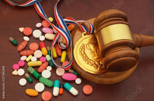 Judge gavel, gold medal and doping on table, sport arbitration court concept. photo