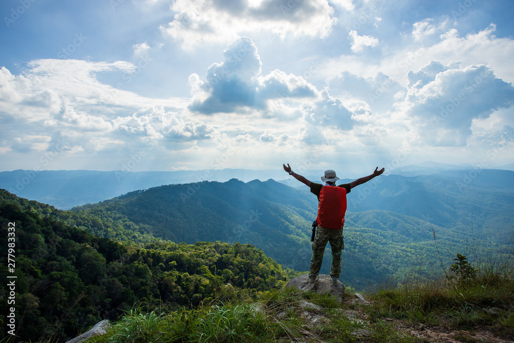 Silhouette of man hold up hands on the peak of mountain,success concept