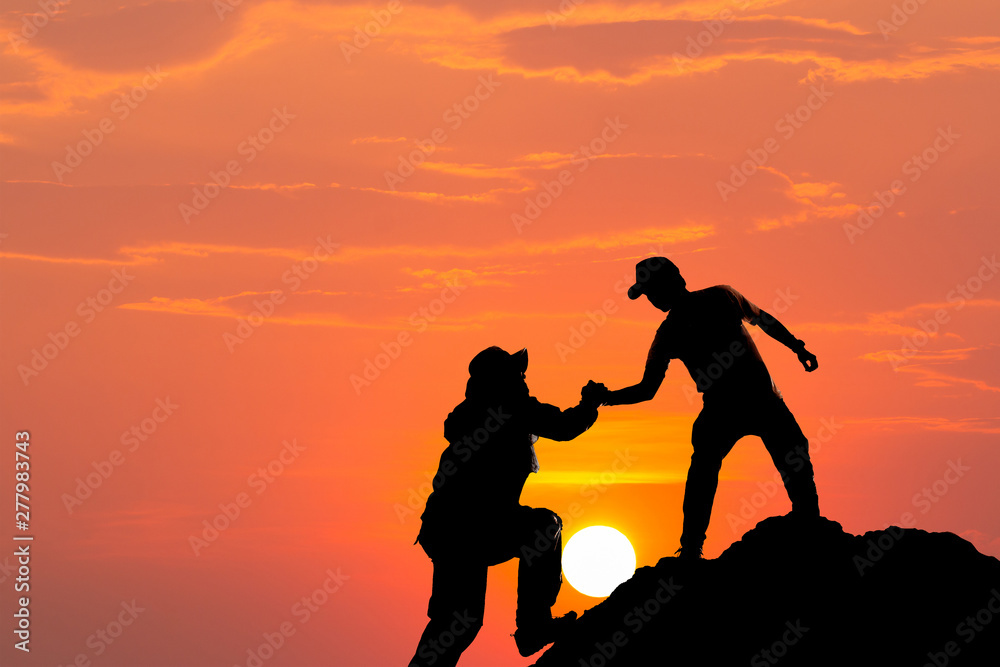 Silhouette of man hold up hands on the peak of mountain,success concept