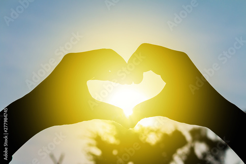 love shape hand silhouette at sunset