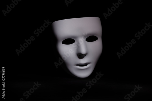mask on black background in shadow