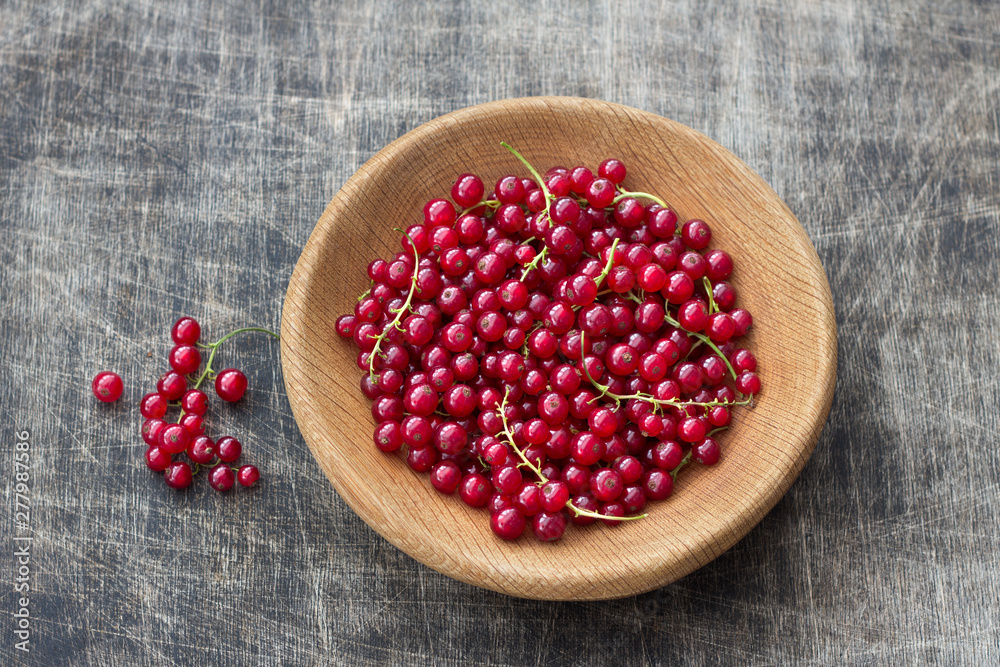 Fresh organic red currants in a wooden bowl on a dark wooden background, rustic style, top view, horizontal Fresh organic red currants in a wooden bowl on a dark wooden background, rustic style, top view, horizontal