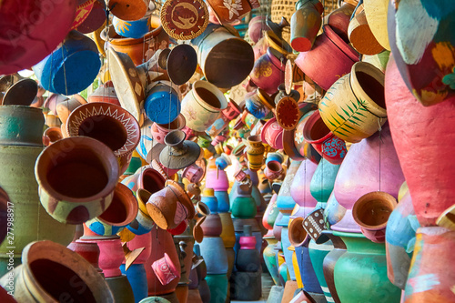 Local pottery craft shop on small street of Ubud, Bali. A lot of clay pots hang on strings as abstract background. Shallow focus