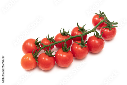 A branch of red cherry tomatoes on a white background. Small and juicy vegetable is rich in vitamins and trace elements. Healthy food. Fresh and organic vegetables. Raw food