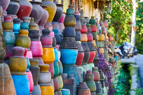 Local pottery craft shop on small street of Ubud, Bali. A lot of clay pots hang on strings as abstract background. Shallow focus