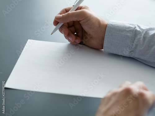 Business correspondence. Cropped shot of man holding pen over blank sheet of paper. Copy space.