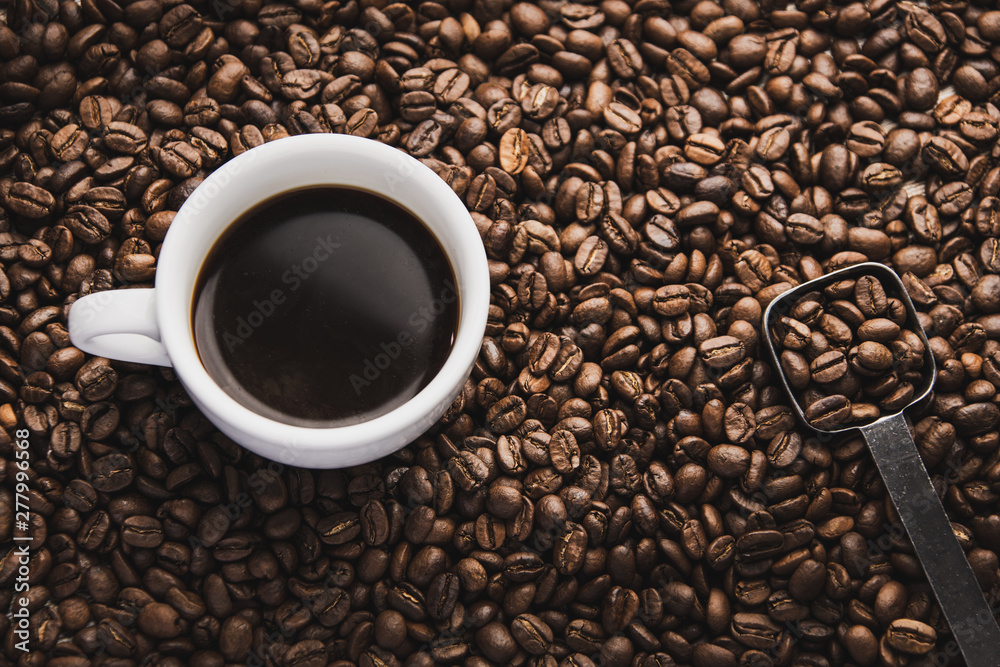 Fototapeta premium cup of coffee and spoon on brown beans 