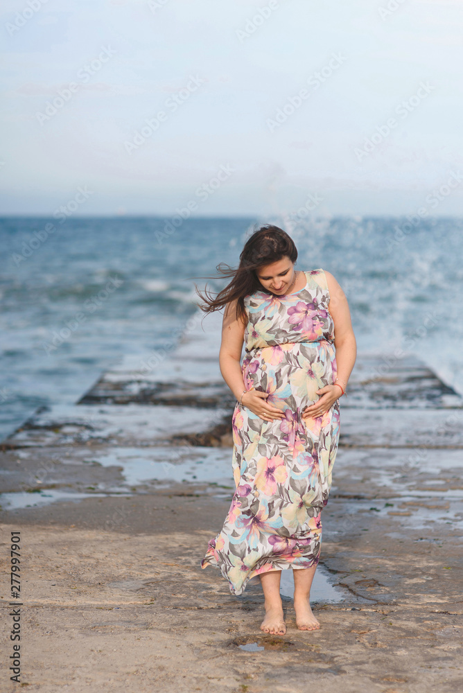 pregnant woman in dress looking at belly pregnant woman in dress looking at belly