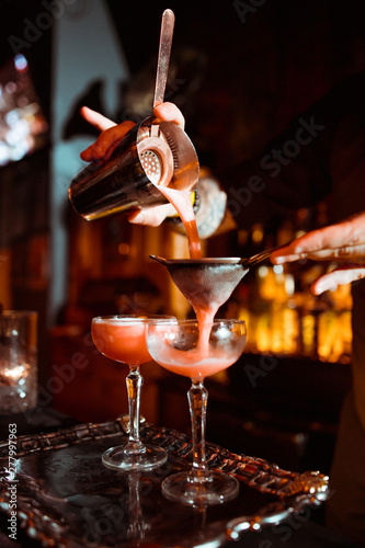 Expert barman is making cocktail at night club photo