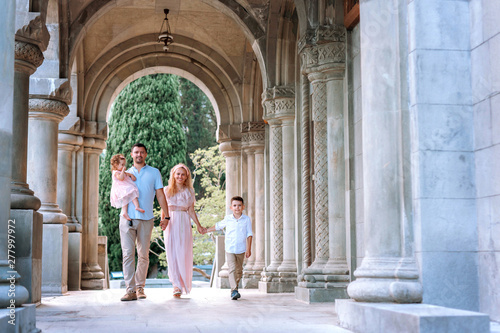 Family, mom, dad, daughter and son walk in the old church.