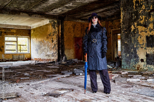 Girl in a black cloak and hat posing in an abandoned, ruined house. Unusual photo shoot © keleny