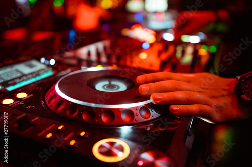 Dj mixing outdoor at beach party festival with crowd of people in background - Summer nightlife view of disco club outside - Soft focus on hand - Fun ,youth,entertainment and fest concept