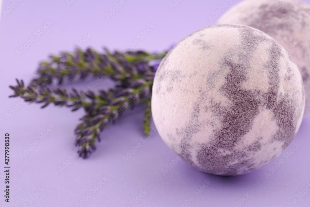 Obraz premium Lavender Bath Bomb. striped bath bombs set and sprigs of lavender close-up on a lilac background.Organic body cosmetics 