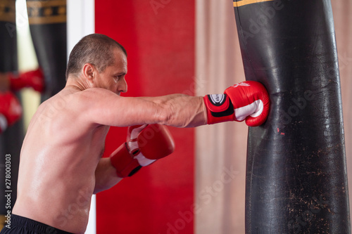 Boxer working with heavy bag © czamfir