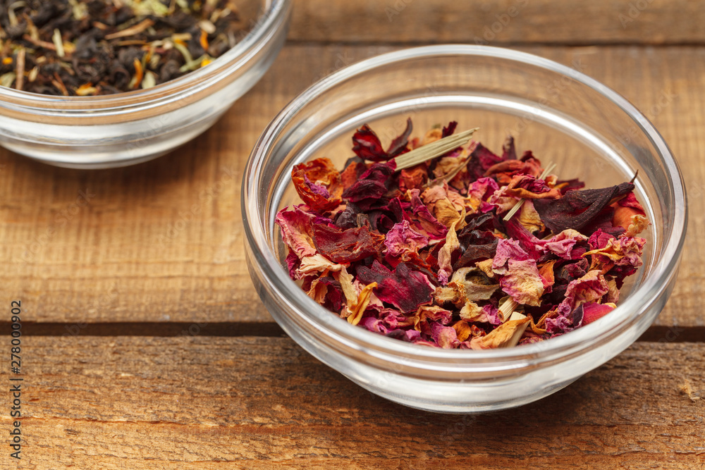 Aromatic dry tea in bowls on wooden background Aromatic dry tea in bowls on wooden background