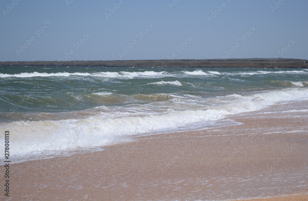 Sea view with waves and sandy beach.