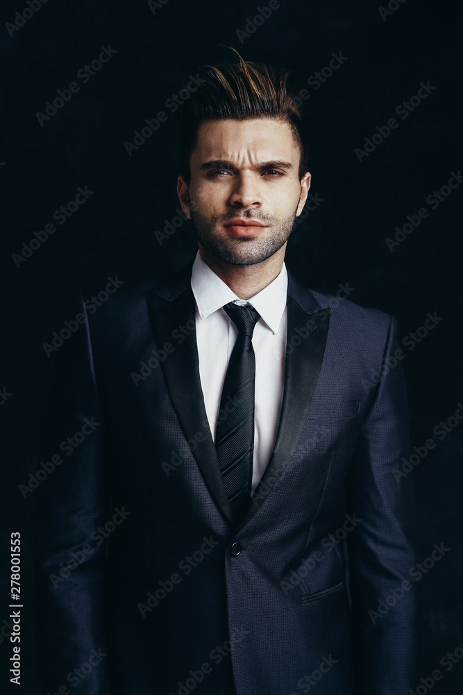 Fashion male portrait in a studio. Formal black suit. Fashion male portrait in a studio. Formal black suit.