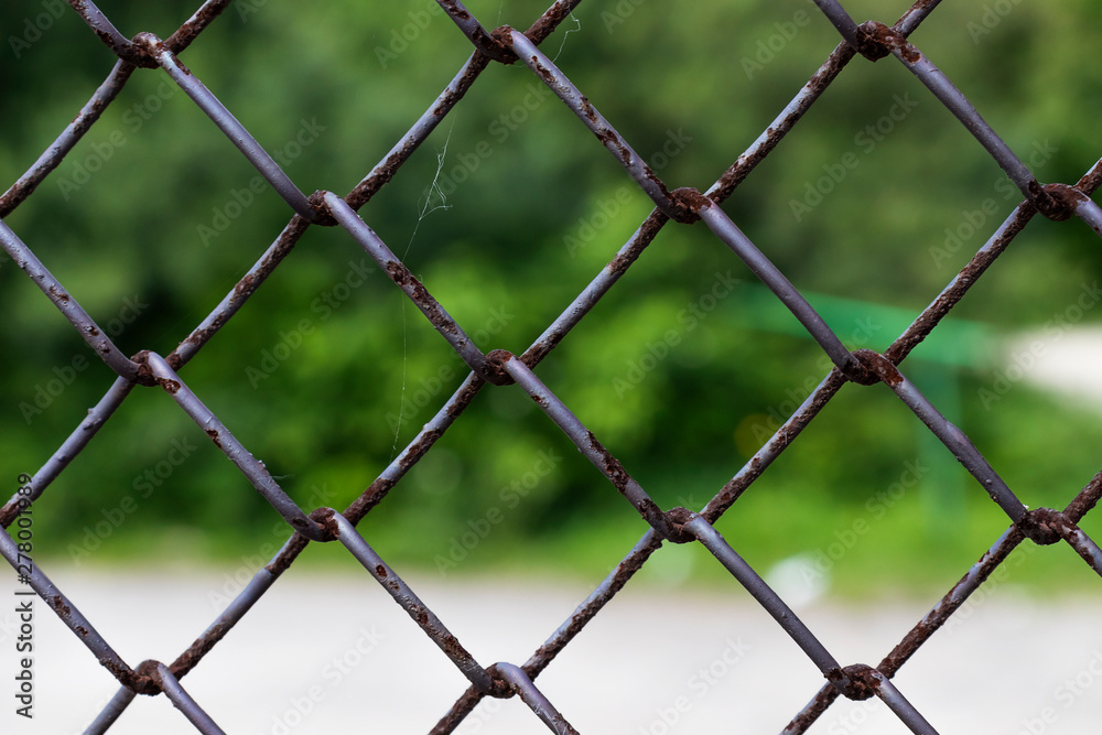 Rows of wire mesh and rusty metal pillar of fence. Wire mesh grid texture. Grunge backdrop. Rustic patterned textures.