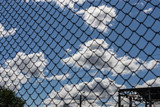 Iron fence on a blue sky with clouds.