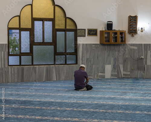 Muslim believer prays in prayer room of the Ahmadiyya Shaykh Mahmud mosque in Haifa city in Israel photo