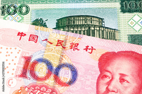 A close up image of a one hundred yuan note from the People's Republic of China with a one hundred ruble note from Belarus photo