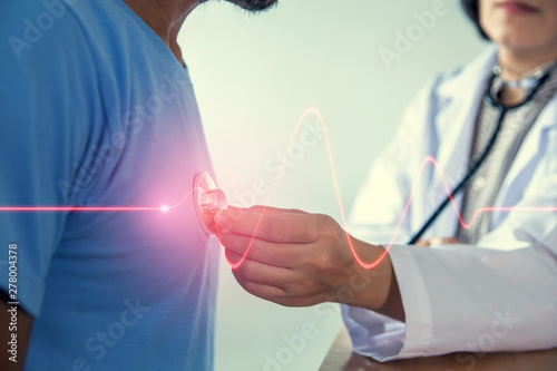 Asian female doctor checking patient heart rate in the hospital. photo