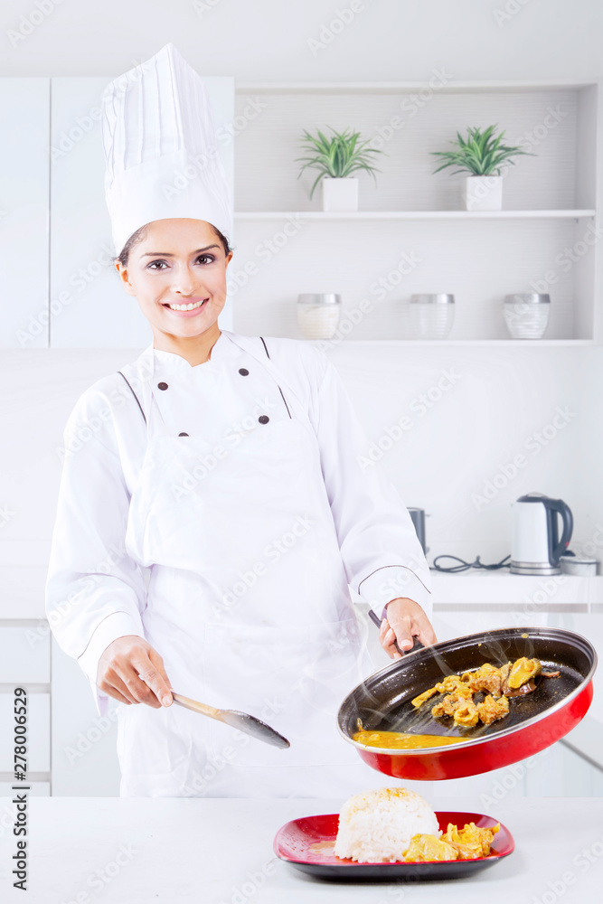 Indian female chef pours tripe soup into a plate Indian female chef pours tripe soup into a plate