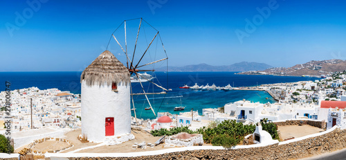 Blick über die Stadt und den Hafen der Insel Mykonos im Sommer mit traditioneller Windmühle und weißgewaschenen Häusern, Kykladen, Griechenland